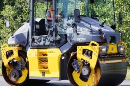 Vacature walsmachinist wegenbouw bij Versluys & Zoon met asfaltwals tijdens asfaltwerkzaamheden.